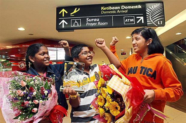 (from left) Prevena, Rasyikash and Sushmeetha celebrating during their arrival at KLIA. Image from The Star