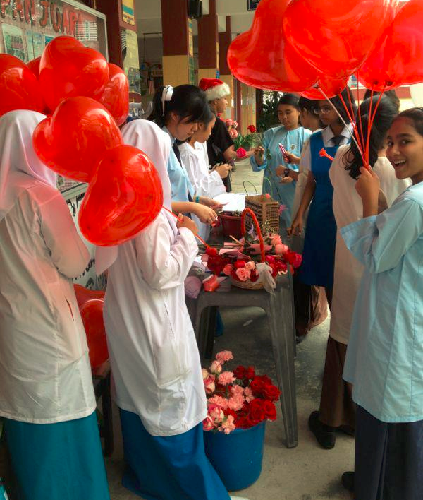 Interact Club selling heart-shaped balloons and flowers. Image from their Facebook.
