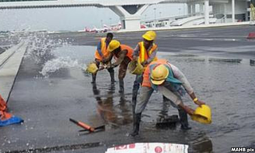 klia2 worker water collect bucket flooding ponding Image from Malaysiakini