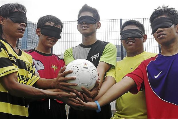 blind football team holding ball