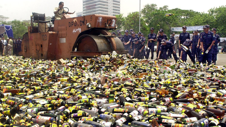 Local government workers destroy bottles of alcohol in a pre-Ramadan anti-alcohol campaign, Tuesday, Nov. 9, 2004, in Jakarta, Indonesia. Every Ramadan the government conducts raids at unlicensed liquor stores and then destroys the liquor in a pubic display. During Ramadan, observant Muslims refrain from eating, drinking, smoking and sex from dawn to dusk. (AP Photo/Irwin Fedriansyah)