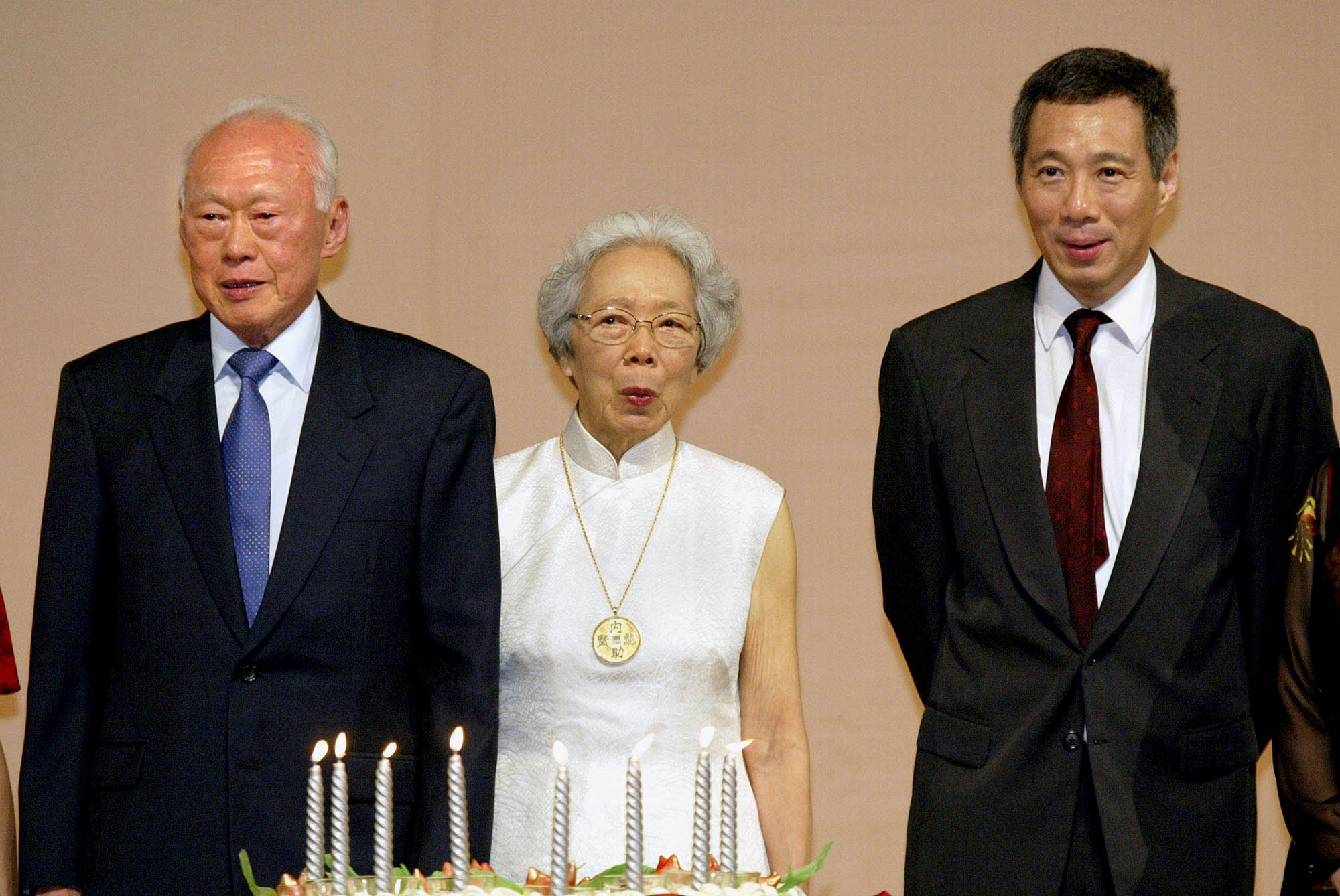 ** FILE ** Singapore's Deputy Prime Minister Mr Lee Hsien Loong, right, Lee's father and Singapore's Senior Minister Lee Kwan Yu, left, and his mother Kwa Geok Choo observe the senior Lee's 80th Birthday in this Sept. 16, 2003 file photo in Singapore. Singapore's government has announced Saturday, July 17, 2004 that Lee will take over as prime minister, replacing Goh Chok Tong on Aug. 12. (AP Photo/Ed Wray, File)