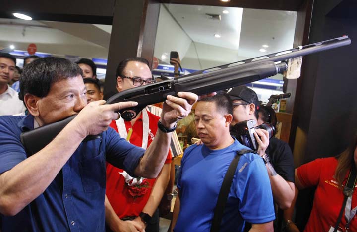Davao City Mayor Rodrigo Duterte together with Senator Allan PEter Cayetano, checks a heavy shotgun, during the opening of the 23rd AFAD Defense and Sporting Arms Show, at the Megatrade Hall of the SM MEgamall in Mandaluyong CIty, Novemebr 11, 2015. The event is the longest running gun show in the country that promotes security, self defense, responsible gun ownership and shooting as a sport. It features different kinds of firearms and ammunitions. It runs from Novemebr 11 to 15, 2015. (Mark Balmores)