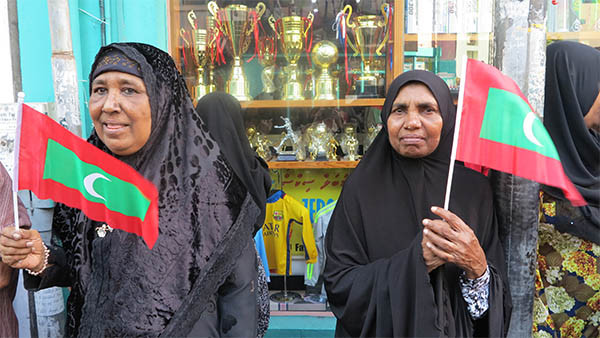 Women of Maldives holding up a Maldivian flag. Photo from huffingtonpost.com