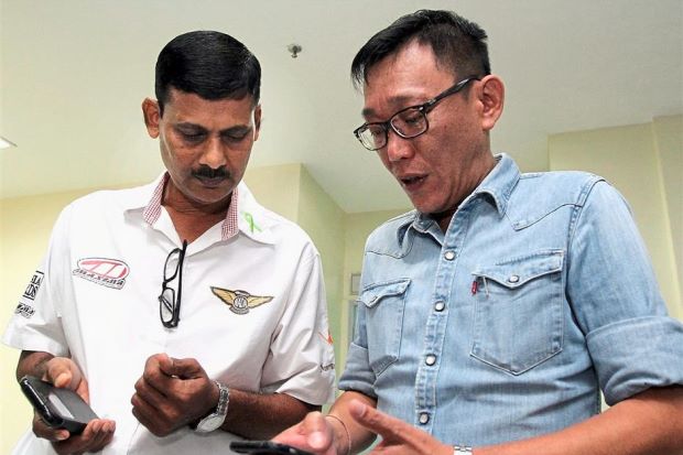 Mark Kok Wah (right) sharing Carmen Mark's photo with Nadarajan who donated his son's organs after he died in an accident. Image credit to The Star. 
