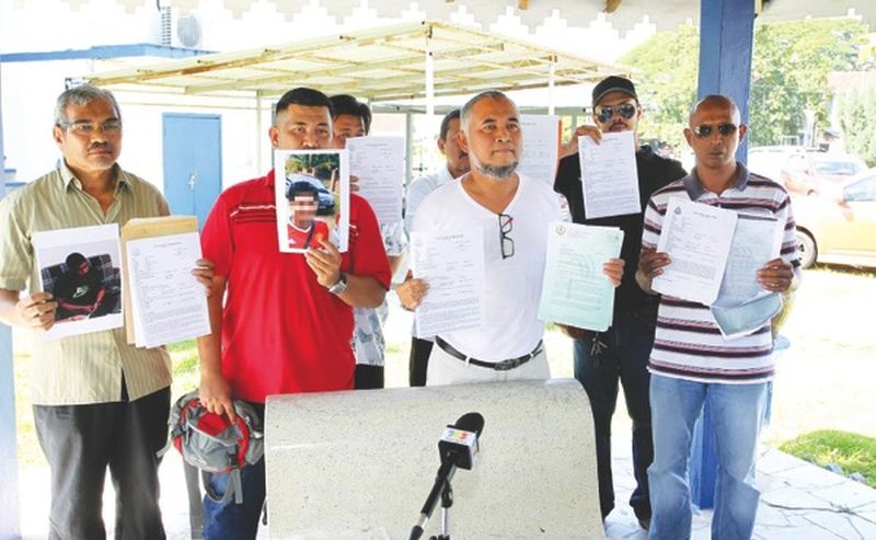 The contractors with the police report and an image of "Faiz". Image from MALAY MAIL/ Farhan Najib. Note: Please blur the conman picture.