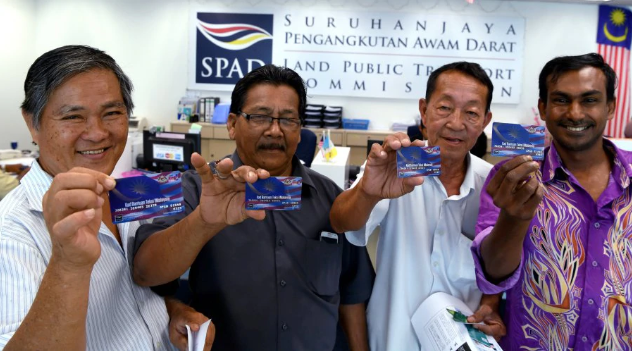 Taxi drivers holding up their 1Malaysia Taxi Aid cards. Image from New Straits Times
