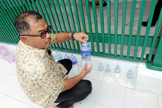 Water bottles placed near the Sultan's tomb, to infuse them with the Sultan's blessings. Img from Berita Harian.