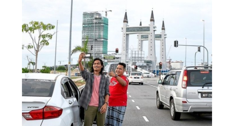 Visitors taking selfies with the bridge. Img from The Nation