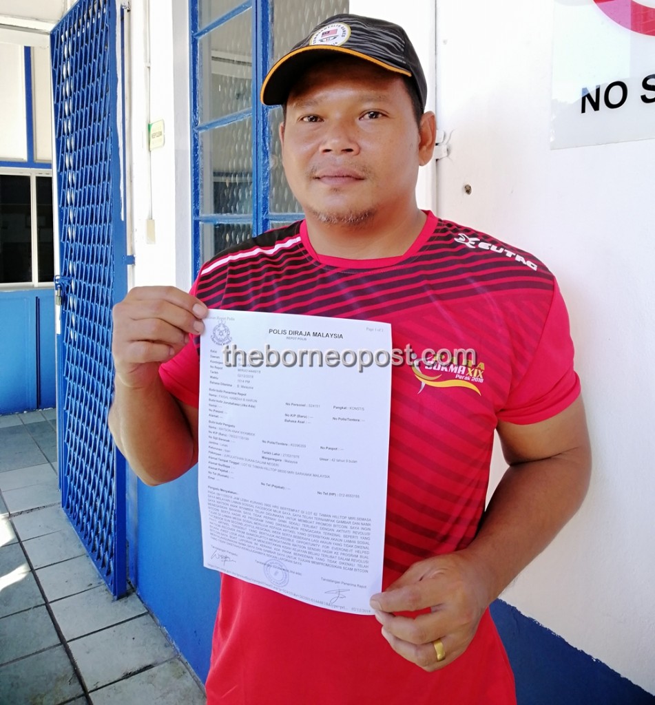 Watson showing the police report he made. Image from Borneo Post