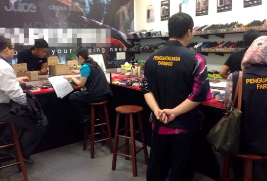 Pharmaceutical enforcement officers conducting a raid at a vape shop. Image from: NST 