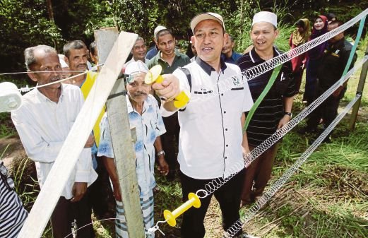 Educating people on the use of an electric fence as part of the SPEG. Img from Harian Metro.