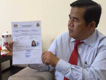 Abdul Aziz with a sample of the Census card. Img from The Borneo Post